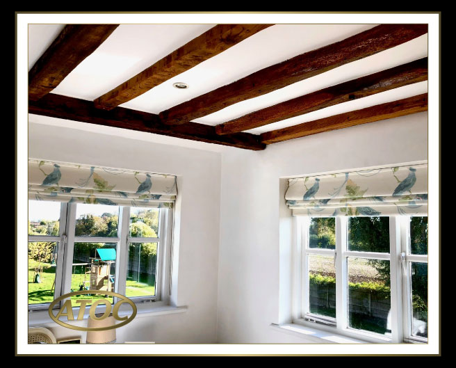 Close-up of Roman blind construction showing face fabric, blackout lining, interlining and invisible horizontal stitch line on a Velcro-headed track